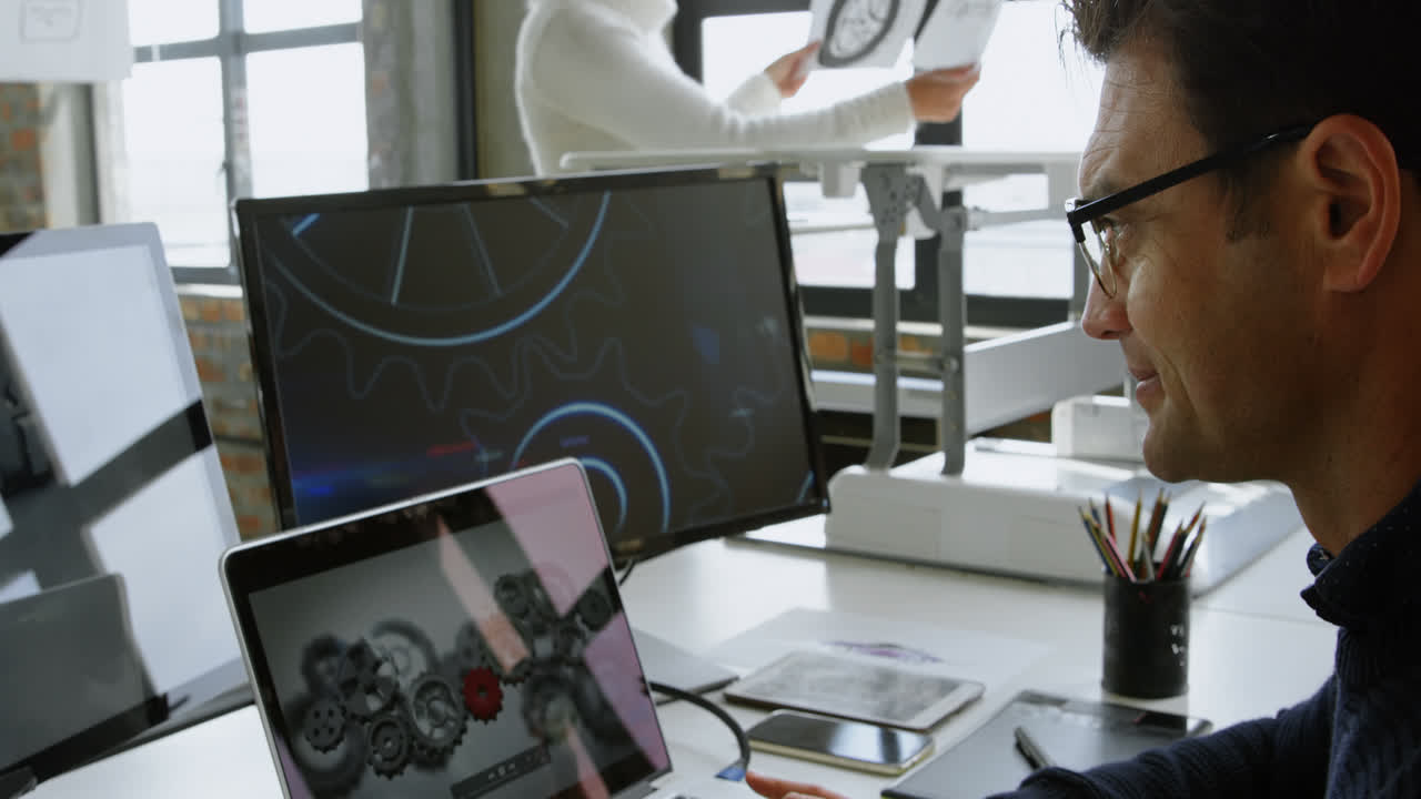 Car designer using laptop at desk 4k