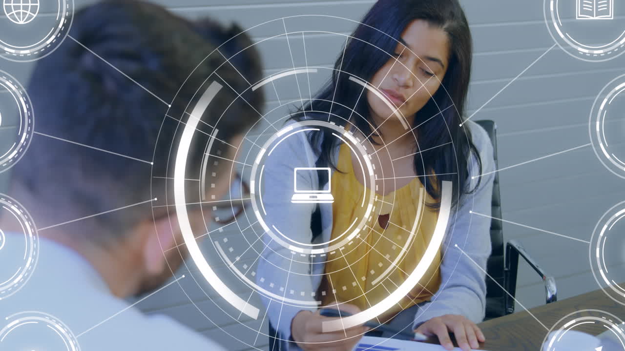 animación de iconos digitales contra hombres y mujeres diversos discutiendo sobre un documento en la oficina.