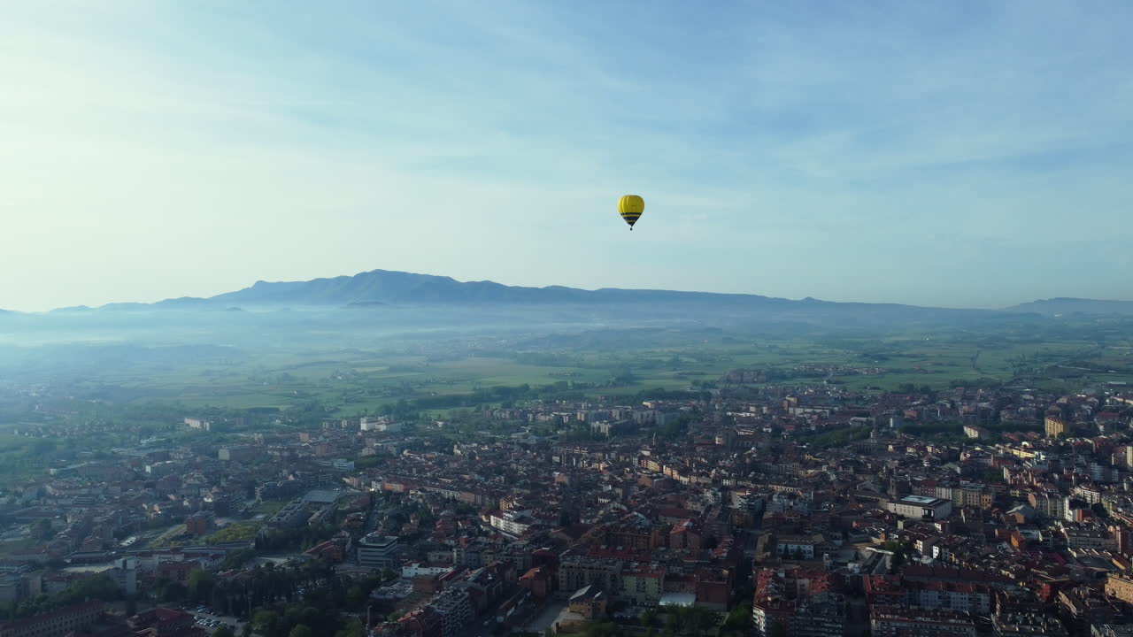 Hot Air Balloon over a City and Mountains