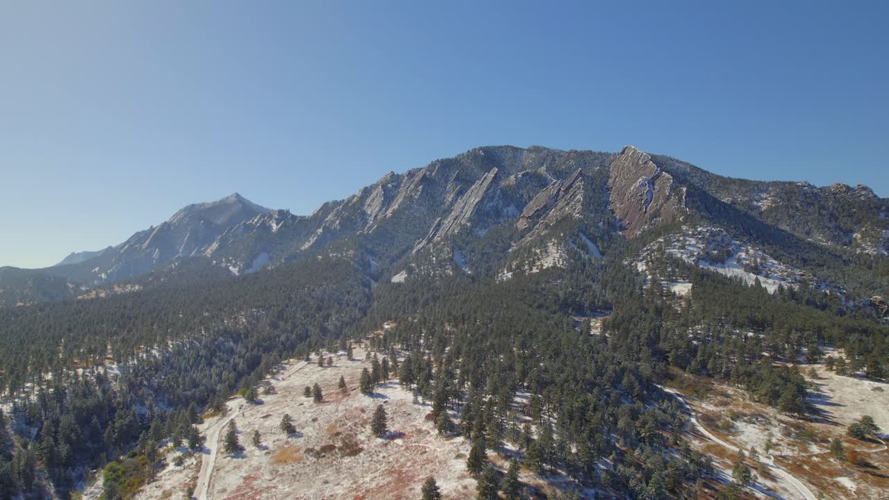 nieve cubriendo el paisaje de la naturaleza flatirons en un día claro de otoño en boulder, colorado, ee.uu. drone video aéreo