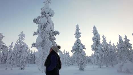 chica disfrutando del paisaje en el bosque nevado en laplandia, finlandia, círculo ártico