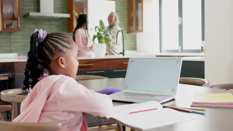 Chica-Afroamericana-Teniendo-Clase-En-Línea-Usando-Una-Computadora-Portátil-Con-Espacio-Para-Copiar,-Cámara-Lenta