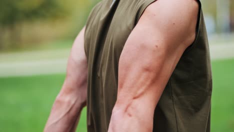 muscular athletic man training on machine in park