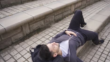 young man resting outdoors, finding peace, thoughtful and happy.