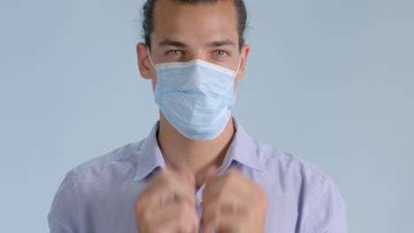 el hombre muestra cómo ponerse correctamente la máscara facial para la protección contra el coronavirus - cierre medio