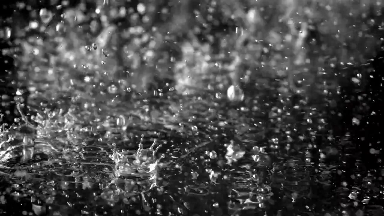 Slow Motion Rain Droplets Splashing on a Dark Water Surface