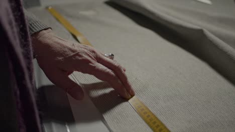 dressmaker taking measure of fabric to design cloth