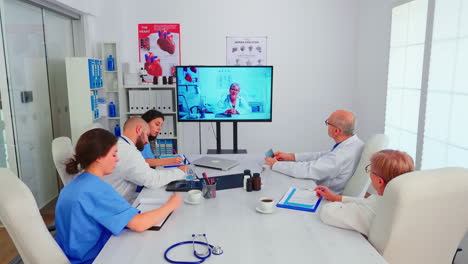grupo de médicos discutiendo con médicos expertos durante una videoconferencia