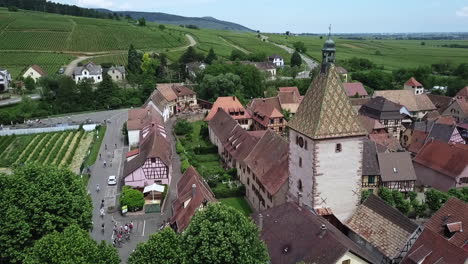 a stationary aerial footage of the clock tower while revealing the houses, roads and traffic within the village