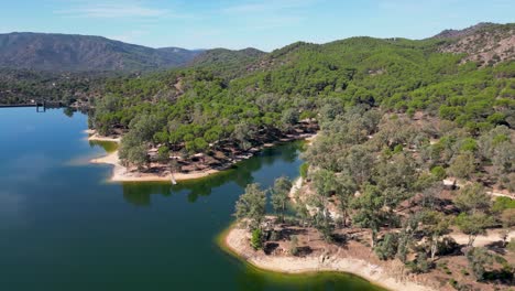 órbita aérea del lago encinarejo con montañas y bosques de la sierra de andujar paisaje