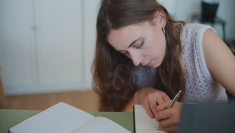 woman writing homework in notebook