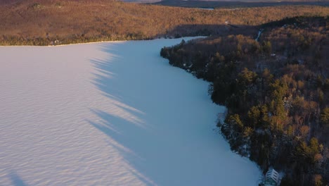 Aerial-tilt-up-to-reveal-a-railroad-trestle-in-northern-maine-at-sunset