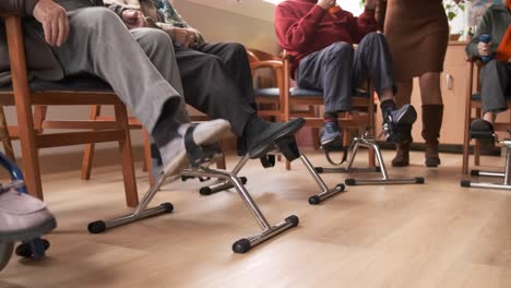 senior people doing pedal exercises at rehabilitation center