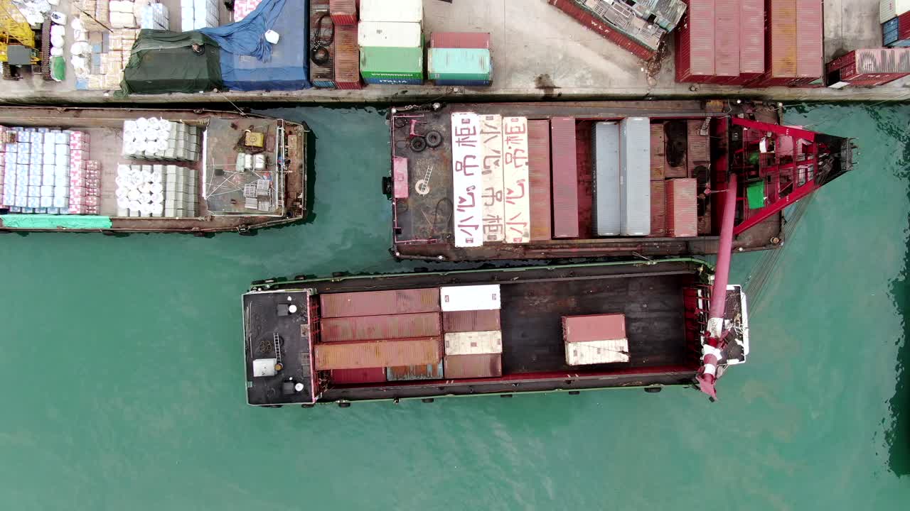 pequeñas barcazas de contenedores de tipo alimentador que operan en el muelle de pilar de hong kong