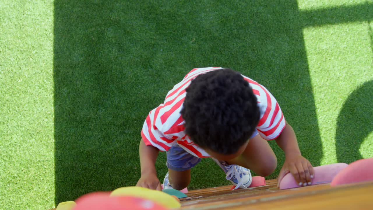 High angle view of African American schoolboy playing in school playground on a sunny day 4k
