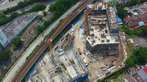 aerial shot drone flyover residential building construction site located next to ktm railway at seputeh, kuala lumpur, malaysia, slowly revealing the complex interchange of nearby highways