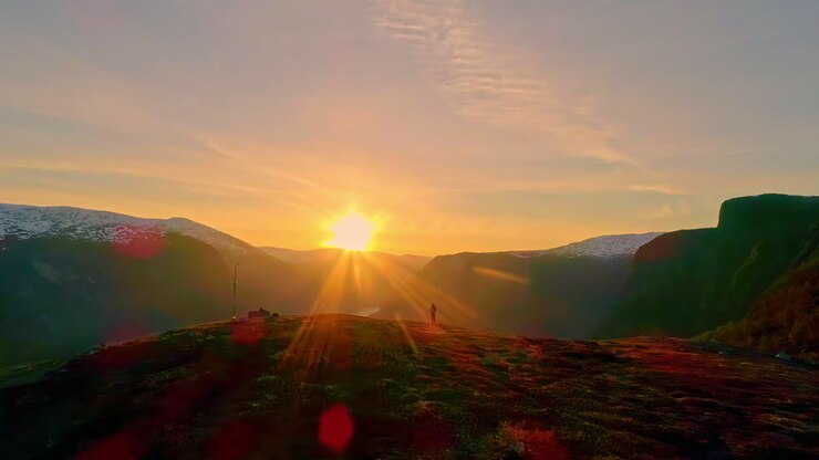 Aerial drone shot flying over mountain top revealing beautiful scenery of Aurland, Norway at sunrise