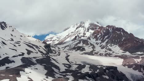 Aerial-panoramic-view-of-stunning-mountain-range-partially-covered-with-snow