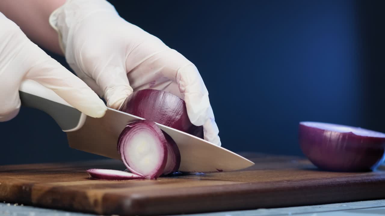 Professional cook prepares vegetarian salad and cuts onion