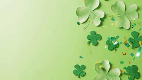 video of saint patricks day green shamrock leaves with copy space on green background