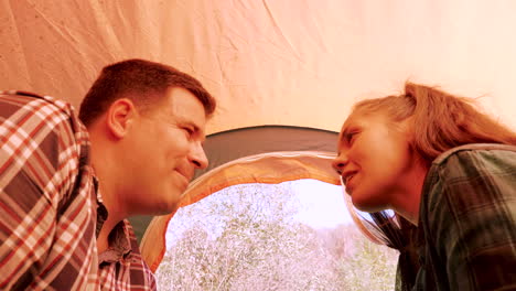 inside view from a camping tent of couple smiling at each other