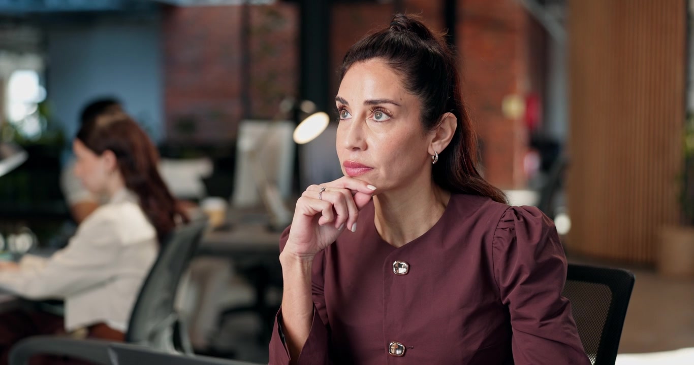 Donna professionista pensierosa mentre lavora al computer portatile in ufficio