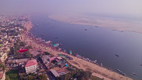 aerial view of assi ghat with ganga river and boats at banaras, varanasi, kashi, uttar pradesh, india. day time, moving down, drone shot, 4k.