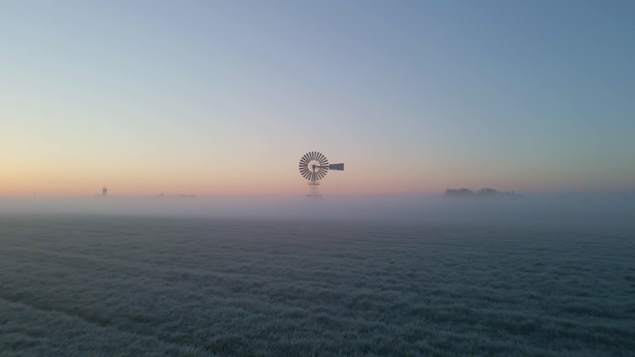 Alba su prato nebbioso con vecchio mulino a vento americano, vista aerea, Frisia