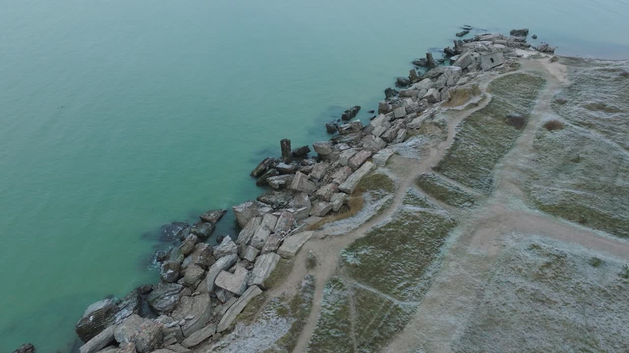 발트해 해변의 카로스타 북부 요새에 있는 버려진 해변 요새 건물의 공중 조감도, 흐린 날, 앞으로 움직이는 넓은 드론 샷, 아래로 기울기