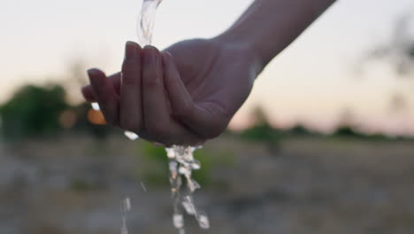 Nahaufnahme-Einer-Frau,-Die-Sich-Bei-Sonnenaufgang-Auf-Ländlichem-Ackerland-Die-Hände-Unter-Leitungswasser-Mit-Frischem-Wasser-Wäscht