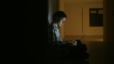 adolescente trabajando en la computadora portátil tarde en la noche