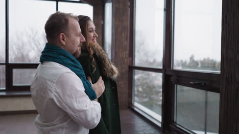 romantic couple looking out window together