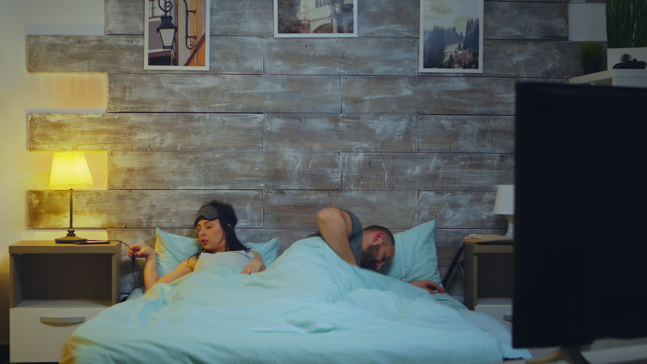 잠자리에 들고 있는 피곤한 부부