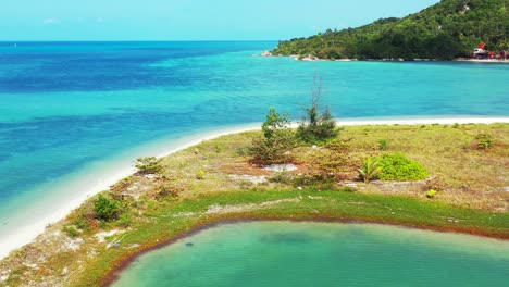 Natürlicher-Hafen,-Begrenzt-Durch-Sandstreifen-Und-Küstenlinie-Der-Tropischen-Insel,-Ruhiges,-Klares-Wasser-Der-Türkisfarbenen-Lagune,-Die-Den-Exotischen-Strand-In-Thailand-Wäscht