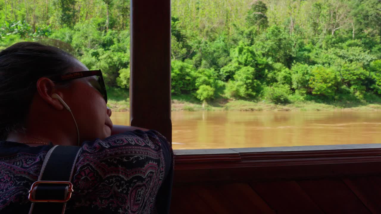 배 위에 머리를 고 있는 젊은 여성, 메콩 강 배경, 풍요로운 초록색 배경