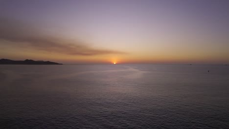 vuelo de drones sobre el mar en calma con puesta de sol en el horizonte, 4k