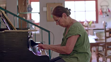 anciana tocando un piano de cola en su casa