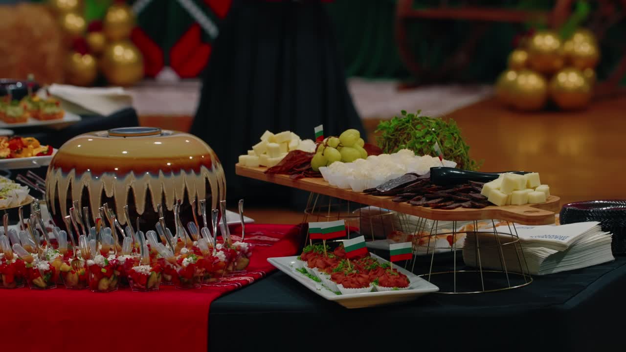 Primo piano di una mini pompa nera che versa acqua in una botte di legno a un buffet gourmet bulgaro con tulipani bianchi.