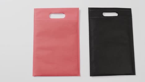 close up of red and black bags on white background, copy space, slow motion