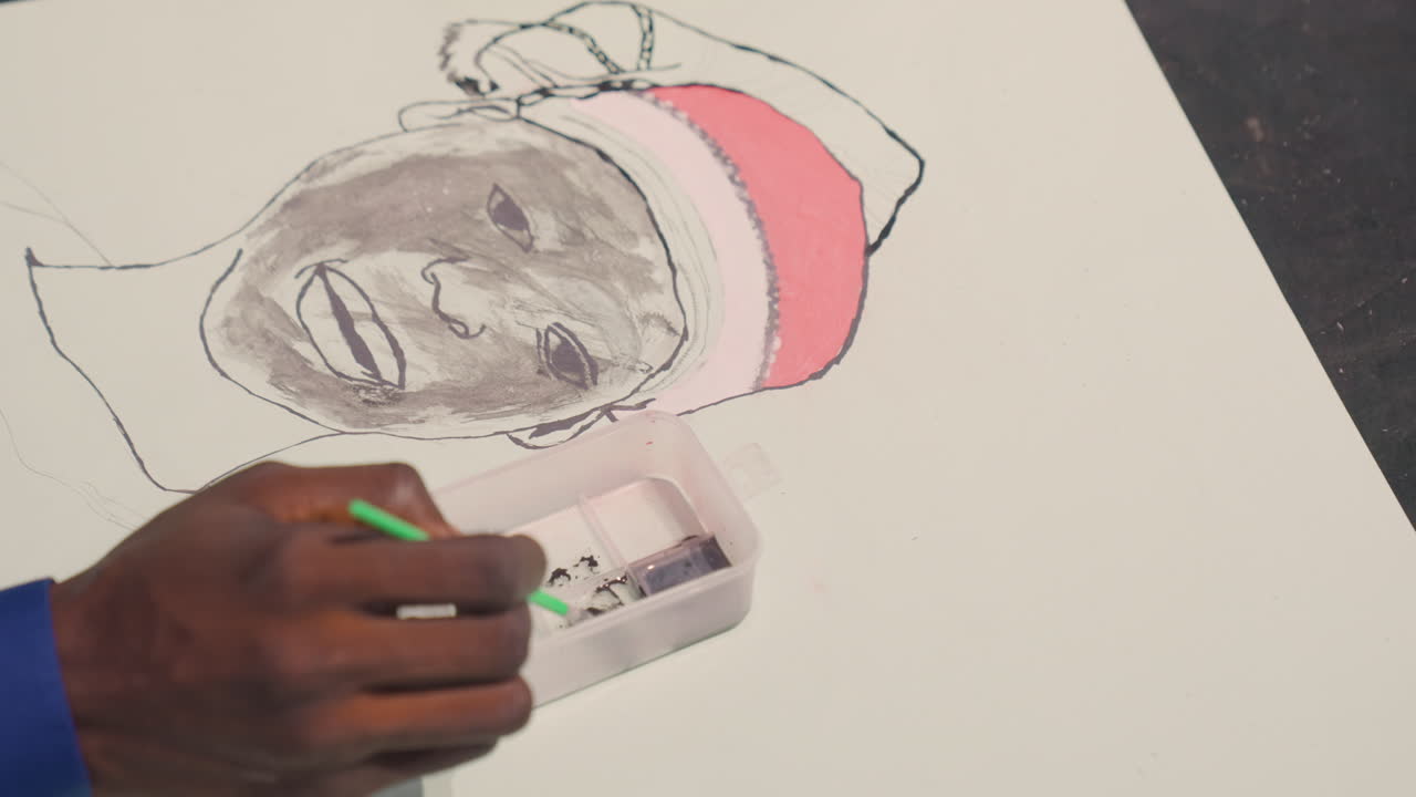 Black painting portrait with green pencil, closeup hand shading smile, pink headwrap on white canvas, plastic palette, blue sleeve, focused light, delicate strokes, textured paper