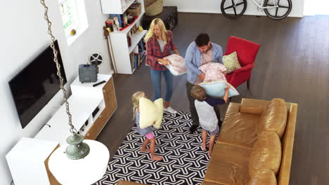 overhead shot of parents having cushion fight with children