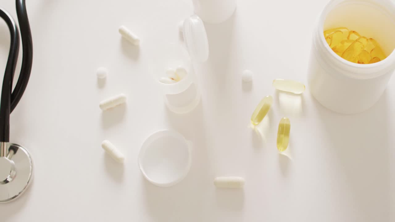 vídeo del estetoscopio, cajas de pastillas, pastillas y cápsulas sobre fondo blanco con espacio para copiar