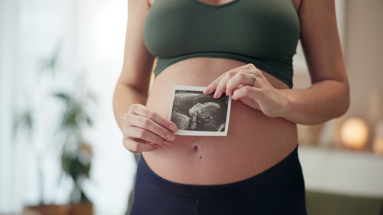Pregnant woman holding ultrasound of her baby