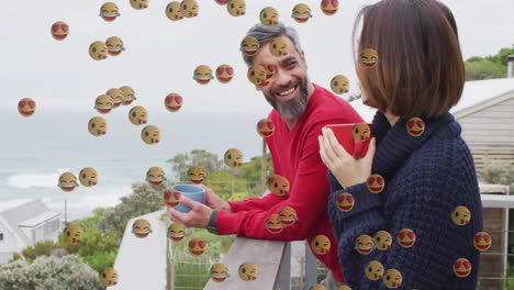couple sipping coffee on balcony while marketing team overlaying floating heart and laugh icons