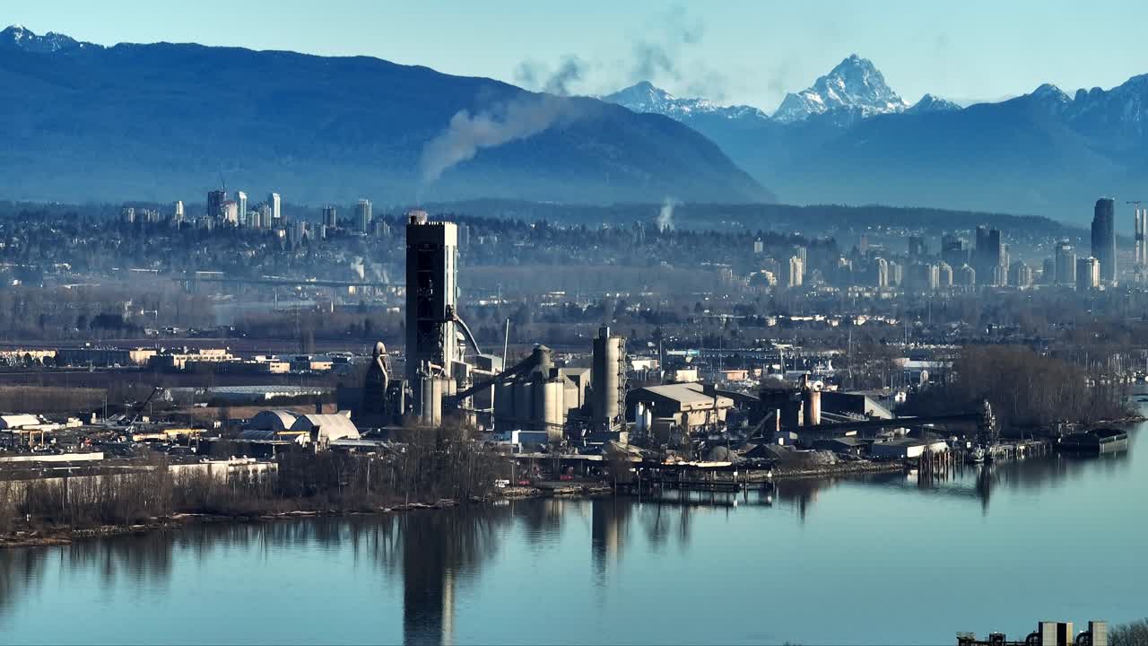 Industrial Cement Factory With Chimney Pipes Emitting Smoke In British Columbia, Canada. Aerial Shot