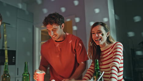 colleagues enjoy home party under disco ball lights close up. overjoyed people