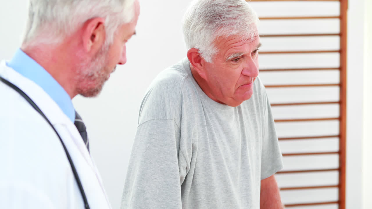 Smiling doctor talking with patient using zimmer frame
