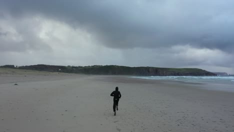 man runs on beach exulting and expressing concept of happiness