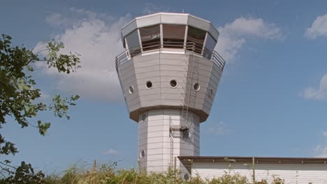 torre de control de tráfico aéreo con cielo azul y nubes