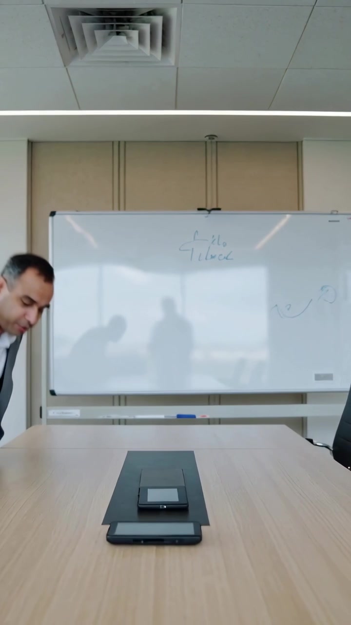 Vertical video: Hand pointing sparking suited man leaning at whiteboard in boardroom, phones